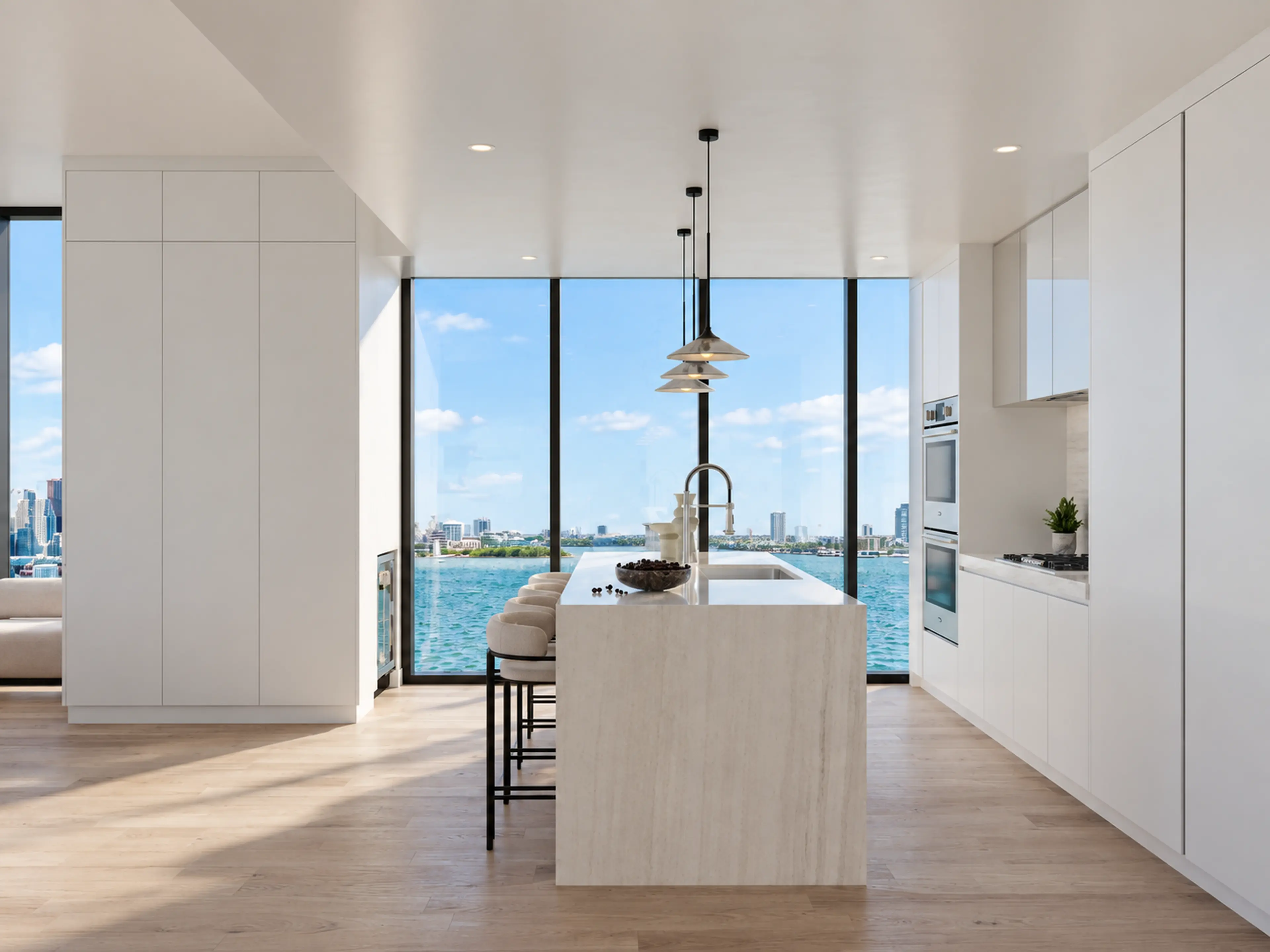 Completed Fort Lauderdale waterfront condo kitchen with a long island and black pendant lights.